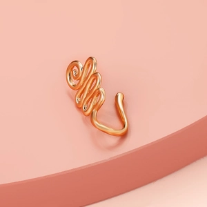 Detailed close-up of a gold-plated spiral non-piercing nose cuff on a pink display stand