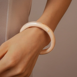 Détail macro d'un bracelet en résine ambrée montrant la texture naturelle et le poli