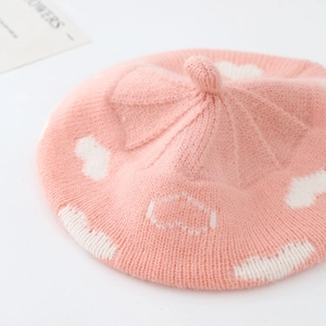 Pink knitted baby beret featuring white cloud jacquard pattern and ribbed edge detail