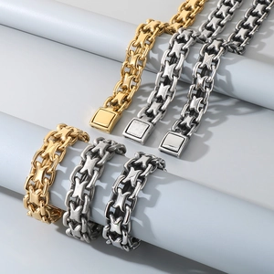 Detail view of gold and silver interlocking cross chain bracelets for men on a display