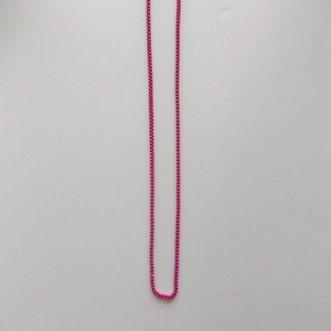 Detailansicht der pinkfarbenen Perlenkette mit quadratischen Gliedern und Textur