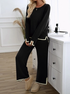 Close-up of women's knit set with white contrast piping and elegant slit cuffs details