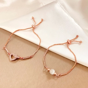 Detail view of rose gold adjustable box chains with pavé heart and opal-like bead