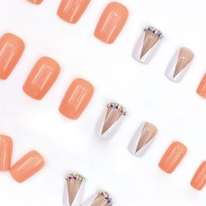 Faux ongles carrés orange avec paillettes et détails de strass style French en V chic