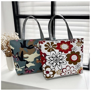 Detailed view of canvas tote bags featuring floral and camouflage butterfly patterns