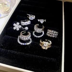 Lustrous zircon pearl ear clips and rings collection displayed on black velvet