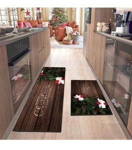 Close-up of Christmas kitchen mats with pine wreaths and Merry Christmas greetings