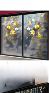 Close-up of golden Christmas window stickers with Merry Christmas text and tree decorations