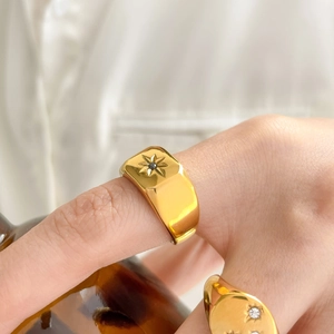 Macro shot of 18K gold signet ring with etched starburst and black gemstone inlay