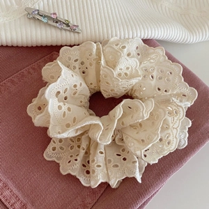 Gros plan sur le chouchou en dentelle beige à double couche et broderie florale