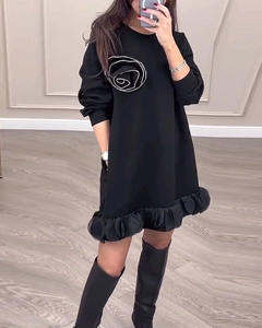 Détail de la robe noire avec ornements floraux 3D et ourlet à volants élégant