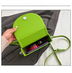 Detail of bright green saddle bag with magnetic closure and striped interior capacity