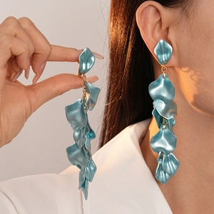 Macro detail of teal acrylic petal tassel earrings with gold-toned metal links