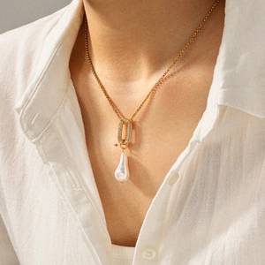 Détail du pendentif perle baroque sur chaîne dorée avec pierres serties