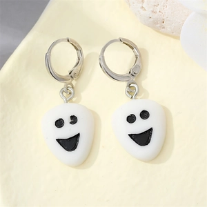Detailed view of creative white ghost face acrylic earrings with black expression and hooks