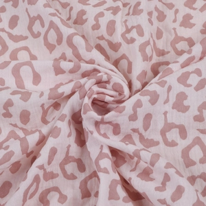 Macro view of soft pink leopard print pattern on double-layer cotton gauze fabric texture