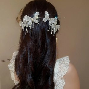 Detailed view of silver butterfly hair clips with shimmering rhinestones and tassels