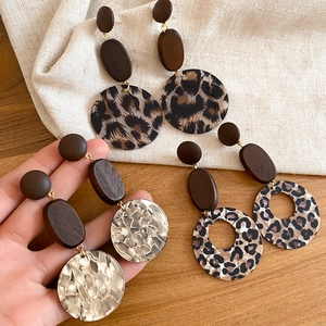 Detail von Vintage-Ohrringen mit Holztextur, Leopardenmuster und goldenem Finish