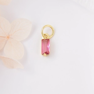 Macro-opname van rechthoekige roze zirkoon hanger met gouden frame voor DIY-sieraden