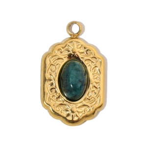 Macro detail of oval green natural stone pendant with gold-plated vintage embossed patterns