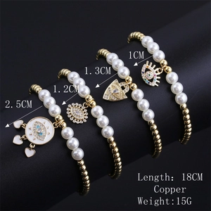 Detailed view of evil eye charms and faux pearl bracelets with copper gold plating