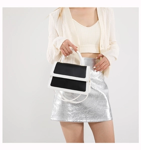 Detail view of the black and white color-block handbag showing its premium leather texture