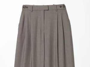 Detail of grey suit trousers featuring double pleats and side adjustable waist buckles