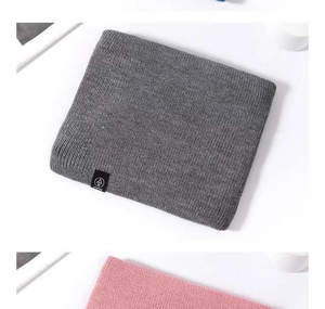 Detail of grey knitted winter neck warmer with fleece lining and branded woven label