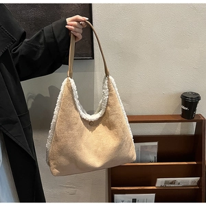 Detailed close-up of khaki faux suede tote bag with white faux shearling trim and magnetic snap