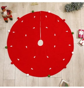 Vue détaillée d'un tapis de sapin de Noël rouge avec motifs blancs et bordures à pompons