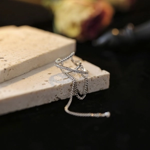 Silver multi-layer ear cuff with zircon inlays and long tassel chain on stone