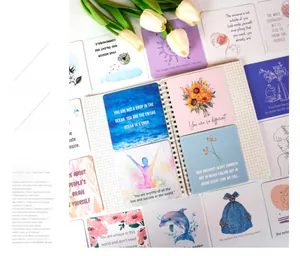 Flat lay of motivational cards with hand-drawn illustrations and quotes on a notebook