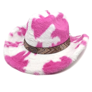Detailed close-up of cow print cowboy hat with a metal bull emblem on the woven band