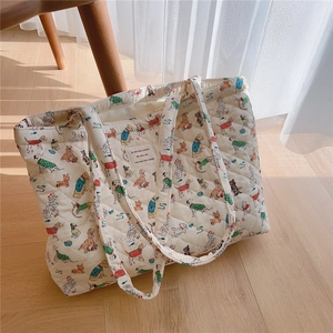 Quilted cotton tote bag featuring colorful dog prints and natural sunlight detail