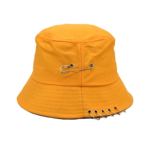 Bright yellow canvas bucket hat with metal safety pin and rings decoration in streetwear style