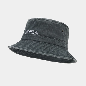 Détail d'un bob en coton délavé avec broderie Brooklyn et œillets métalliques
