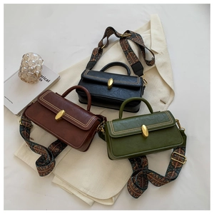Detailed view of vintage square handbags in black, brown, and green with textured straps
