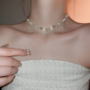 Collier multicouche en perles et cristaux avec pendentif cœur sur le mannequin