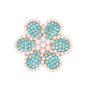 Elegant gold flower brooch with light blue crystal petals and white pearl accents