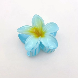 Macro detail of a light blue plumeria hair claw clip with a yellow center gradient finish