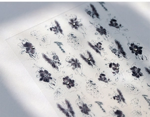 Detailed close-up of retro butterfly nail stickers with crystals and floral embossed art