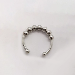 Detalle de siete cuentas metálicas giratorias en un anillo abierto contra ansiedad