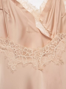 Detailed macro view of champagne silk fabric with exquisite floral lace embroidery edges