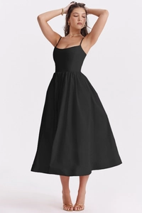 Detailed view of black midi dress showing thin straps and pleated waist detail