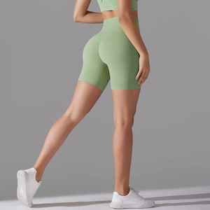 Detail of high-waisted mint green yoga shorts with a seamless fit and butt-lifting design