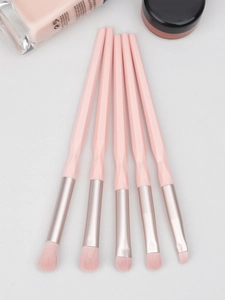 Detail of pink diamond-cut eye makeup brushes with gold ferrule and soft synthetic bristles
