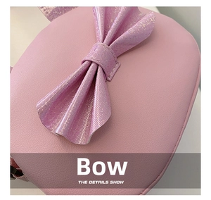 Detail view showing a large glittery pink bow on the litchi pattern PU leather bag