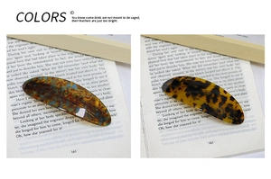 Detailed close-up of acetate geometric hair clips in marble and tortoiseshell patterns