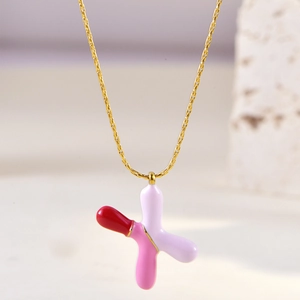 Detail of gold star necklace featuring pink and white enamel inlay on a delicate chain