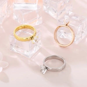 Detailed view of three hammered metal rings in gold, silver, and rose gold with zircon stones
